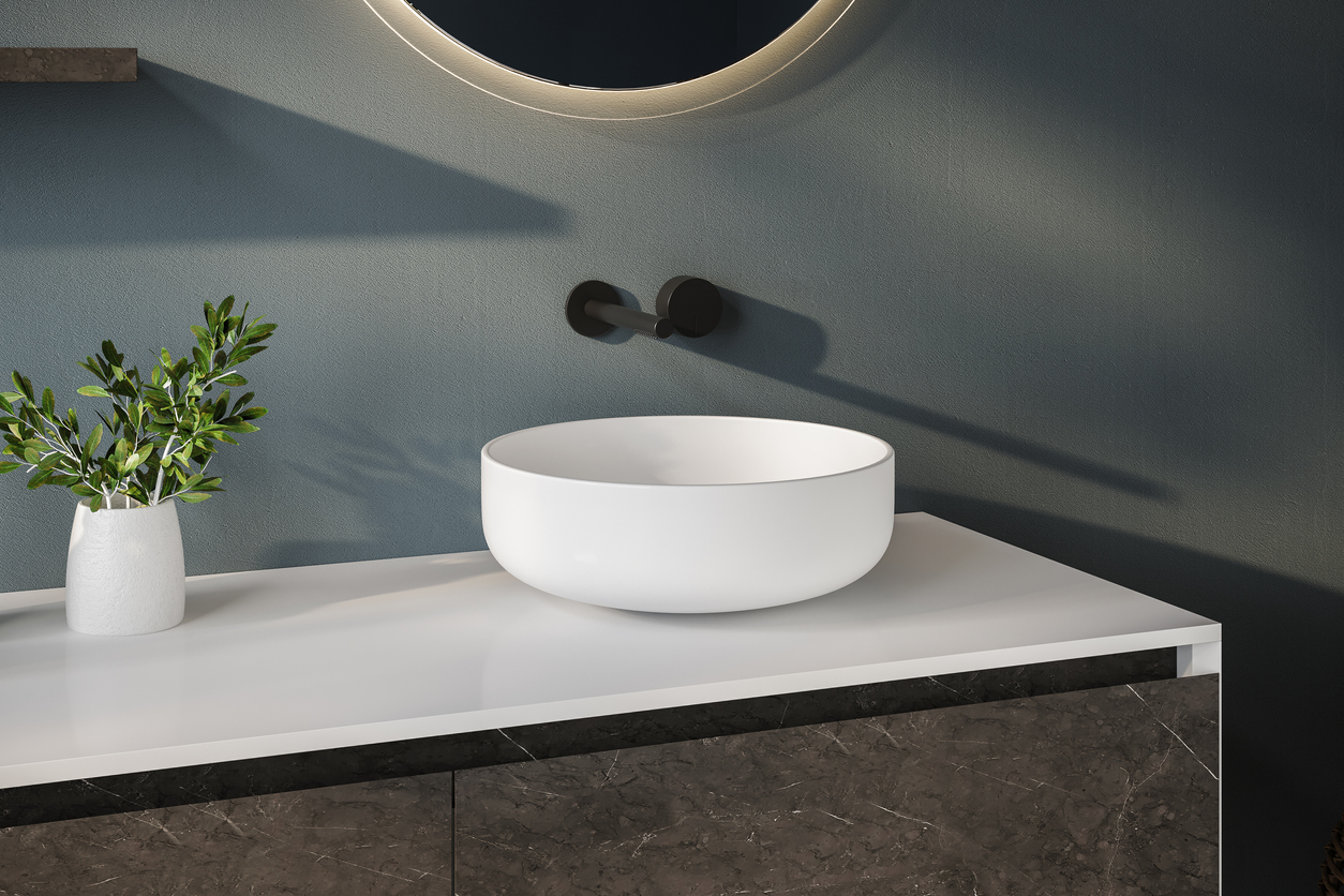 Close up of white sink standing on a wooden vanity unit in a white wall bathroom with a mirror and liquid soap. Relaxation and self care concept hemstädning