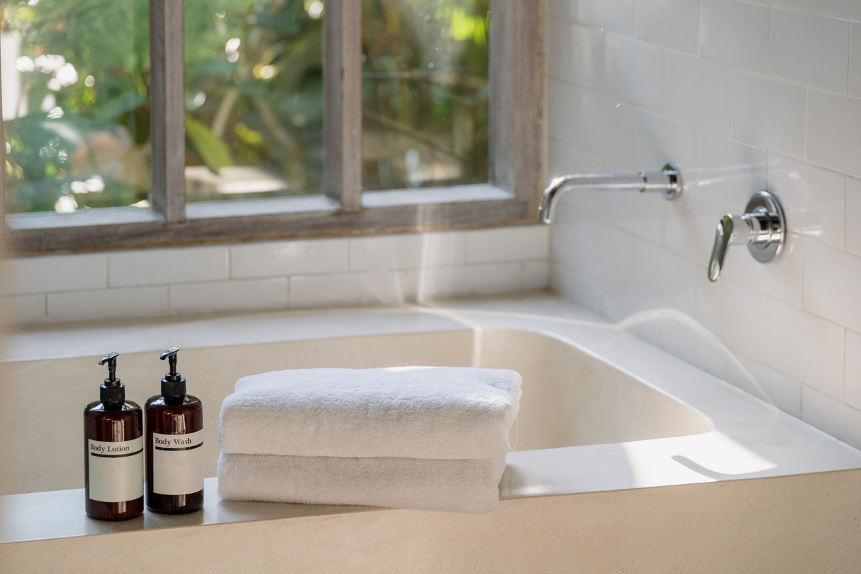 Two bottle of body wash lotion and shower gel on top of white ceramic bathtub hemstädning