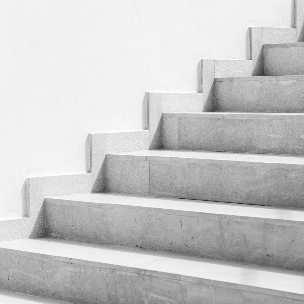 Empty white stone stairway near white wall hemstädning